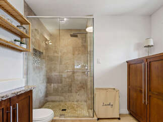 Experience modern comfort in this beautifully appointed bathroom, featuring a spacious glass-enclosed shower with elegant tilework.