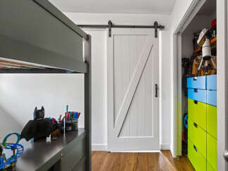 Discover a charming bedroom featuring a modern barn door leading to a spacious closet.