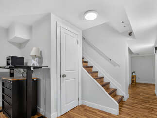 Discover this bright and modern basement space featuring a convenient staircase leading to the upper level.