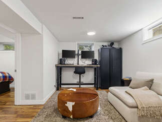 This basement living space features a comfortable seating area with a cowhide ottoman and a plush sofa, perfect for relaxation.