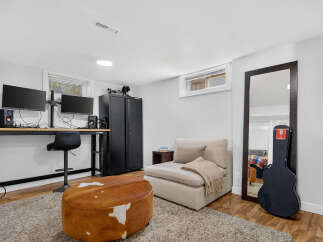 This versatile room features a dedicated workspace with dual monitors and a comfortable chair, perfect for remote work or creative projects.