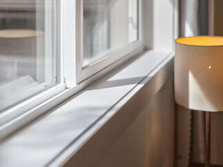 Bathed in natural light, this image showcases a pristine white windowsill, highlighting the clean lines and bright ambiance of the space.