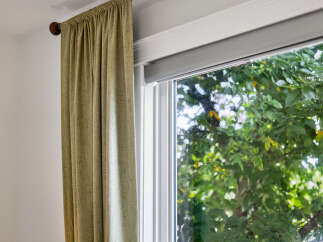 Enhance your living space with elegant drapery and a modern roller blind, offering both style and privacy.