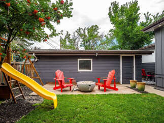 Enjoy outdoor living in this charming backyard featuring a spacious wooden deck, perfect for entertaining.
