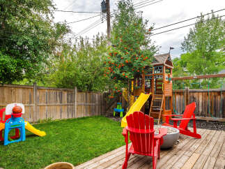Enjoy endless family fun in this spacious backyard, complete with a vibrant playground featuring a slide and swings, and a basketball hoop for active play.