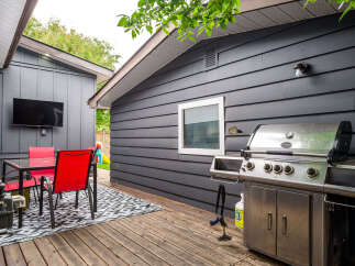 Enjoy outdoor living with this spacious deck featuring a dining area and a large grill, perfect for entertaining.