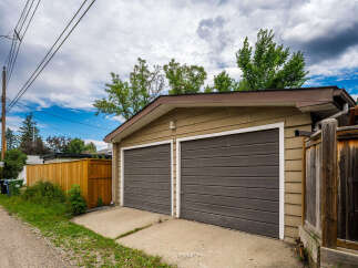 This property features a detached double garage with two dark grey doors, perfect for vehicle storage or a workshop.