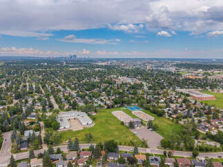 Discover this expansive aerial view showcasing a vibrant suburban neighborhood with a school and recreational facilities.