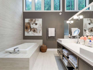 Experience luxury in this modern bathroom featuring a deep soaking tub and a spacious vanity with ample storage.