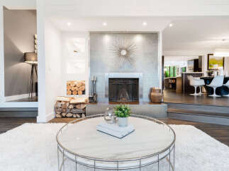 Experience modern living in this stunning home featuring a sleek fireplace with a unique sunburst accent and a spacious open-concept layout.