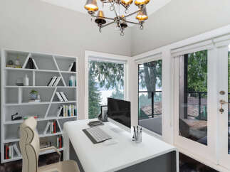 This bright and airy home office features a sleek white desk with a computer setup, complemented by a modern white bookshelf filled with decorative items and books.