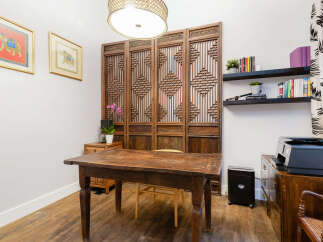 This home office features a rustic wooden desk paired with a decorative wooden screen, creating a unique and stylish workspace.