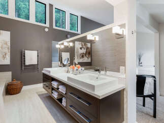 Experience luxury in this modern bathroom featuring a spacious double vanity with sleek dark wood cabinetry and ample storage.