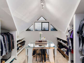 Discover this spacious walk-in closet, featuring ample storage with built-in shelving for shoes and clothing.