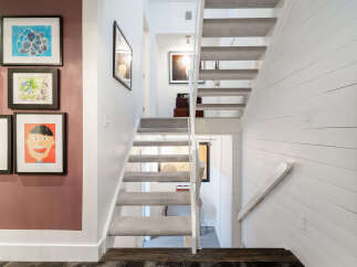 Ascend to the upper levels of this charming home via a carpeted staircase, beautifully complemented by a white shiplap accent wall.