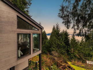 Experience breathtaking ocean views from this modern architectural gem nestled amongst lush evergreen trees.