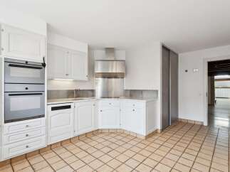 Discover this charming kitchen featuring sleek white cabinetry and modern stainless steel appliances, including a double oven and a built-in dishwasher.