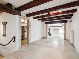 Discover this charming property featuring exposed wooden beams and a rustic stone archway, adding character and warmth to the living space.