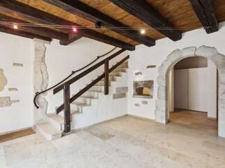 Experience rustic charm with exposed wooden beams and stone accents in this unique interior.
