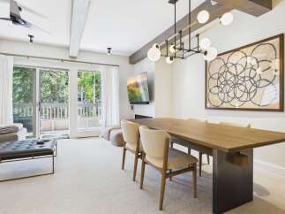 Experience modern mountain living in this stunning dining area, featuring a large wooden table perfect for gatherings and a sleek, contemporary chandelier.