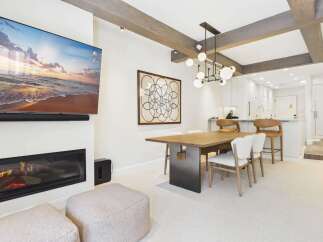 Experience modern living in this beautifully appointed space, featuring a sleek fireplace and a large flat-screen TV perfect for entertainment.