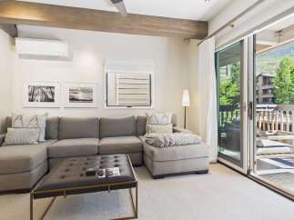 Experience modern living in this stylish living room, featuring a comfortable sectional sofa and a sleek ottoman coffee table.