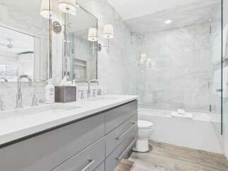 Experience luxury in this stunning bathroom featuring a sleek double vanity with marble countertops and modern chrome fixtures.