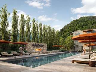 Experience luxury outdoor living with this stunning resort-style swimming pool, complete with a cozy stone fireplace and ample lounge seating.
