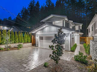Experience modern luxury in this stunning new construction home, beautifully illuminated at dusk.
