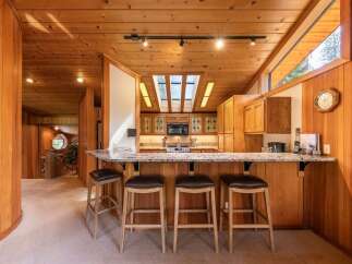 Experience the warmth of this stunning wood-paneled kitchen, featuring a spacious granite island perfect for casual dining and entertaining.