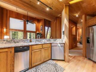 Experience rustic charm in this beautifully appointed kitchen, featuring rich wood paneling and soaring vaulted ceilings.