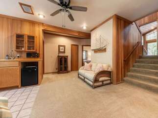 This inviting living space features a charming wet bar with a mini-fridge and ample cabinet storage, perfect for entertaining.