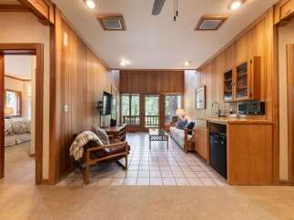 Experience rustic charm in this inviting living space featuring warm wood paneling and a cozy seating area.