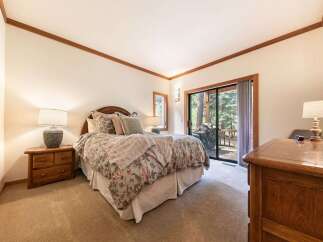 Experience cozy comfort in this charming bedroom, featuring a plush floral comforter and a soft, inviting throw blanket.