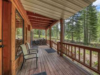 Enjoy the serene mountain lifestyle from this charming cabin's spacious covered porch.