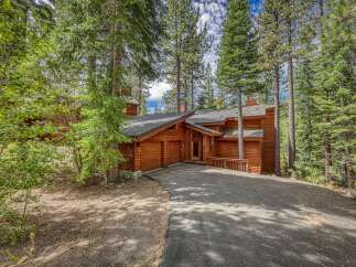 Nestled amidst towering pine trees, this stunning log home offers a serene mountain retreat.