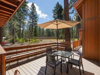 Enjoy outdoor living on this spacious deck, perfect for al fresco dining or relaxing under the shade of a large umbrella.
