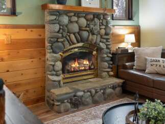 Cozy up by the stunning stone fireplace, a true centerpiece of this inviting living space.
