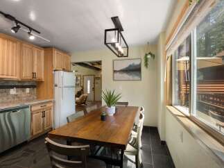 This charming kitchen and dining area features light wood cabinetry and a spacious wooden dining table perfect for family meals.