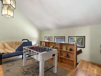 Enjoy endless fun in this recreational loft featuring a foosball table and a cozy futon perfect for lounging.