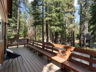 Enjoy the serene mountain setting from this spacious wooden deck, perfect for outdoor relaxation.