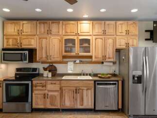This spacious kitchen boasts beautiful light wood cabinetry, offering ample storage and a warm, inviting aesthetic.