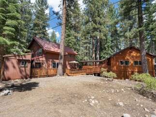 Nestled amongst tall pine trees, this charming wooden home offers a serene retreat.