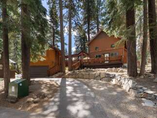 Nestled among tall pine trees, this charming mountain home offers a serene retreat.