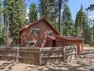 Nestled amidst tall pine trees, this charming wooden cabin offers a rustic retreat.