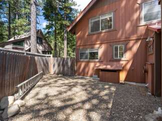 Discover this charming property nestled amongst tall pine trees, offering a private and serene backyard setting.