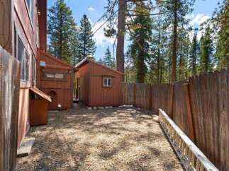 Discover this charming property featuring a rustic wooden exterior and a gravel yard, perfect for outdoor activities.