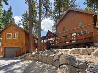 Nestled among tall pine trees, this charming wooden home offers a rustic mountain retreat.