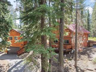 Nestled among tall pine trees, this charming wooden home offers a serene mountain retreat.