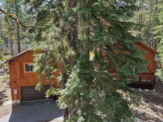 Nestled amongst tall pine trees, this charming wooden home offers a serene mountain retreat.